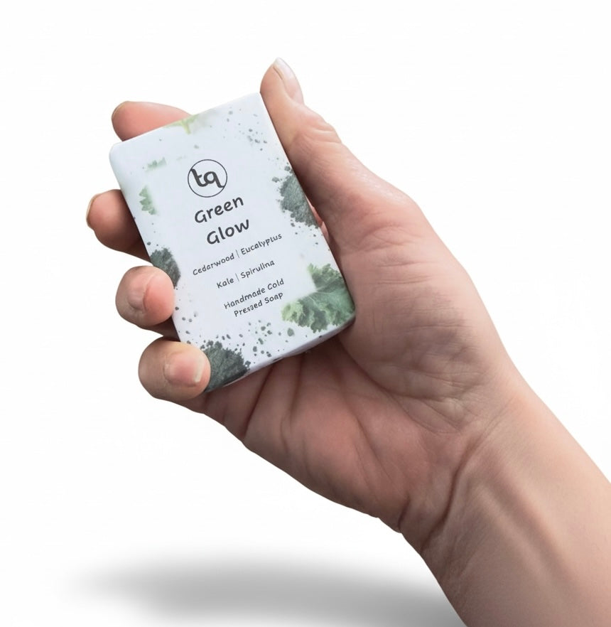 Hand holding a Truequest bar of soap with 'Green Glow' branding on a white background