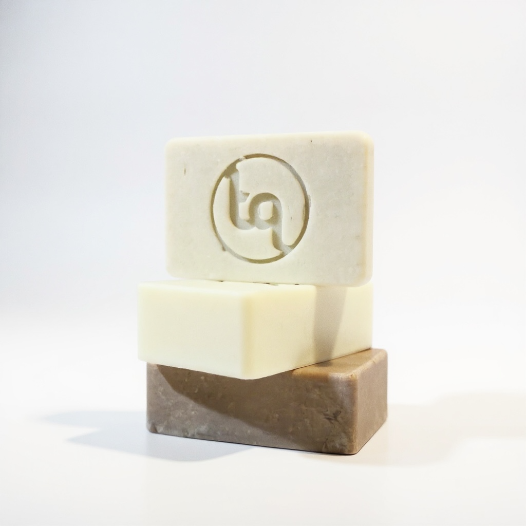 Three bars of soap with Truequest logo on a white background