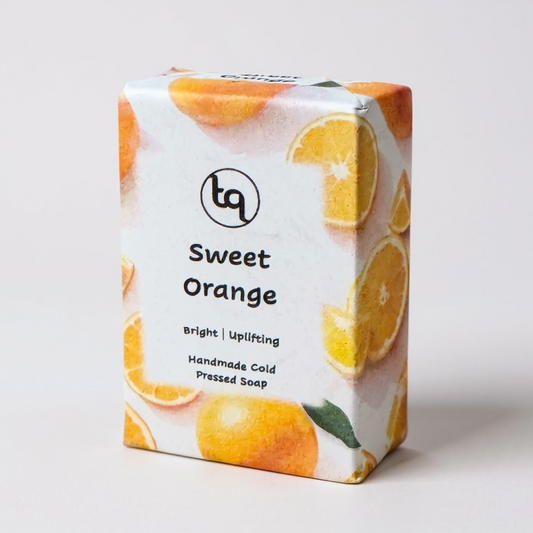 Soap packaging with orange slices and 'tq' branding on a light background