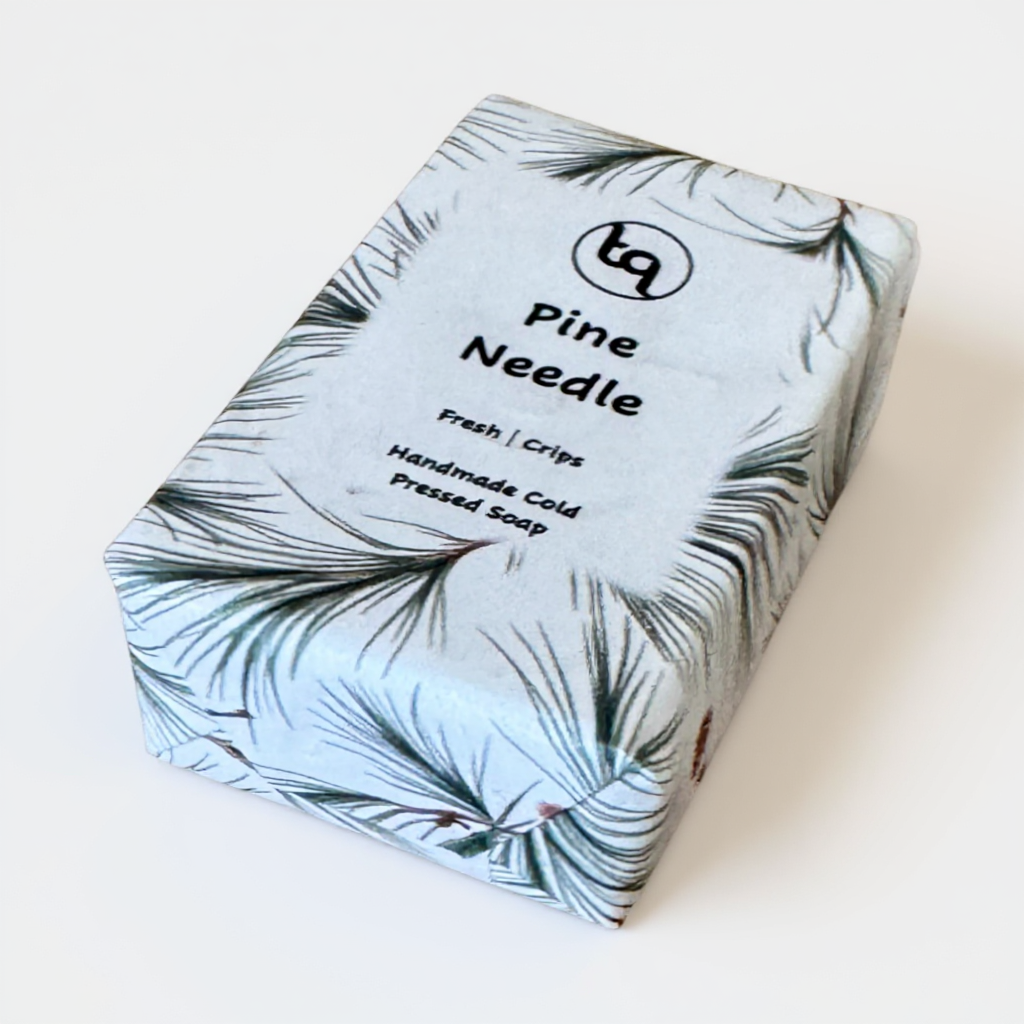 Bar of soap with pine needle pattern packaging on a white background