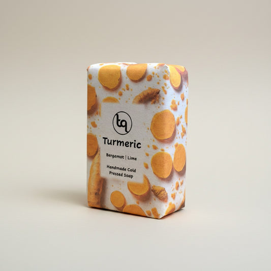 The main product photograph of an unwrapped Truequest turmeric cold-pressed soap bar