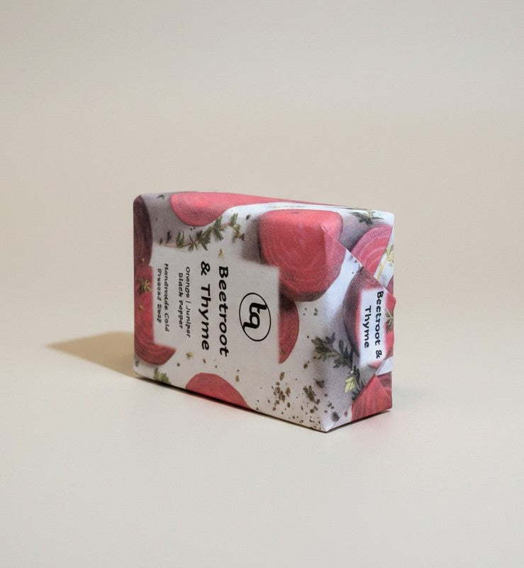 Truequest beetroot and thyme cold-pressed soap bar resting on its side.