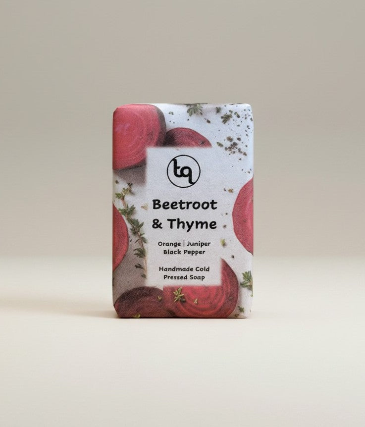 A direct front view of a Truequest beetroot and thyme cold-pressed soap bar, fully enclosed in its clean paper packaging wrapper with the main product label facing forward