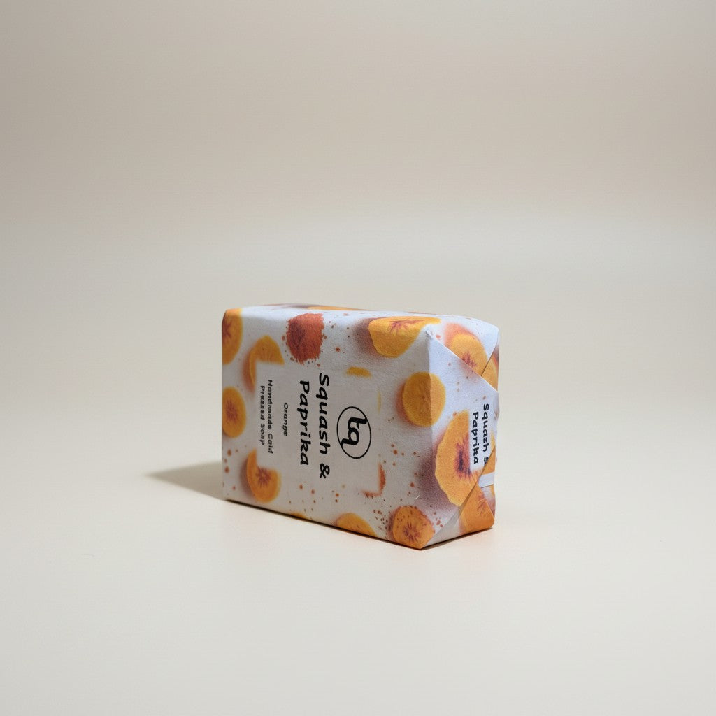 A single rectangular bar of Truequest squash and paprika cold-pressed soap positioned horizontally on its narrow side, highlighting the thickness