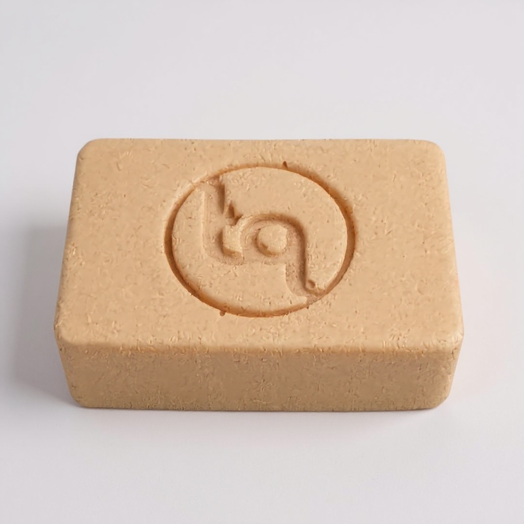 Beige soap bar with Truequest logo on a light gray background