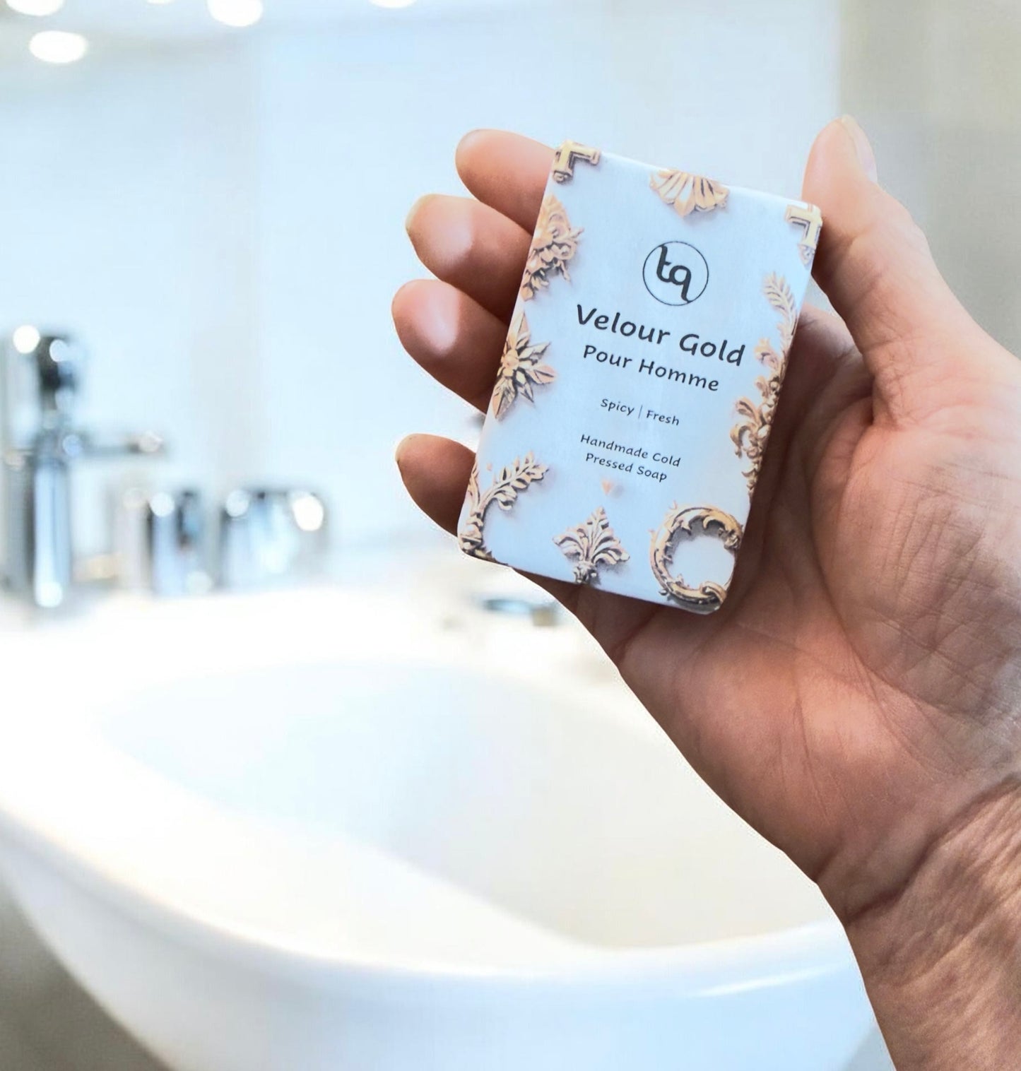 Hand holding a small rectangular product packaging with 'Velour Gold' Truequest Soap branding.