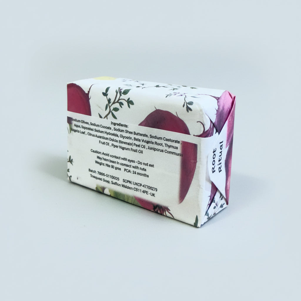 ingredients for a Truequest soap beetroot and thyme bar of soap with a decorative wrapper on a light gray background, Ingredients are beetroot, thyme, orange, juniper and black pepper essential oils.