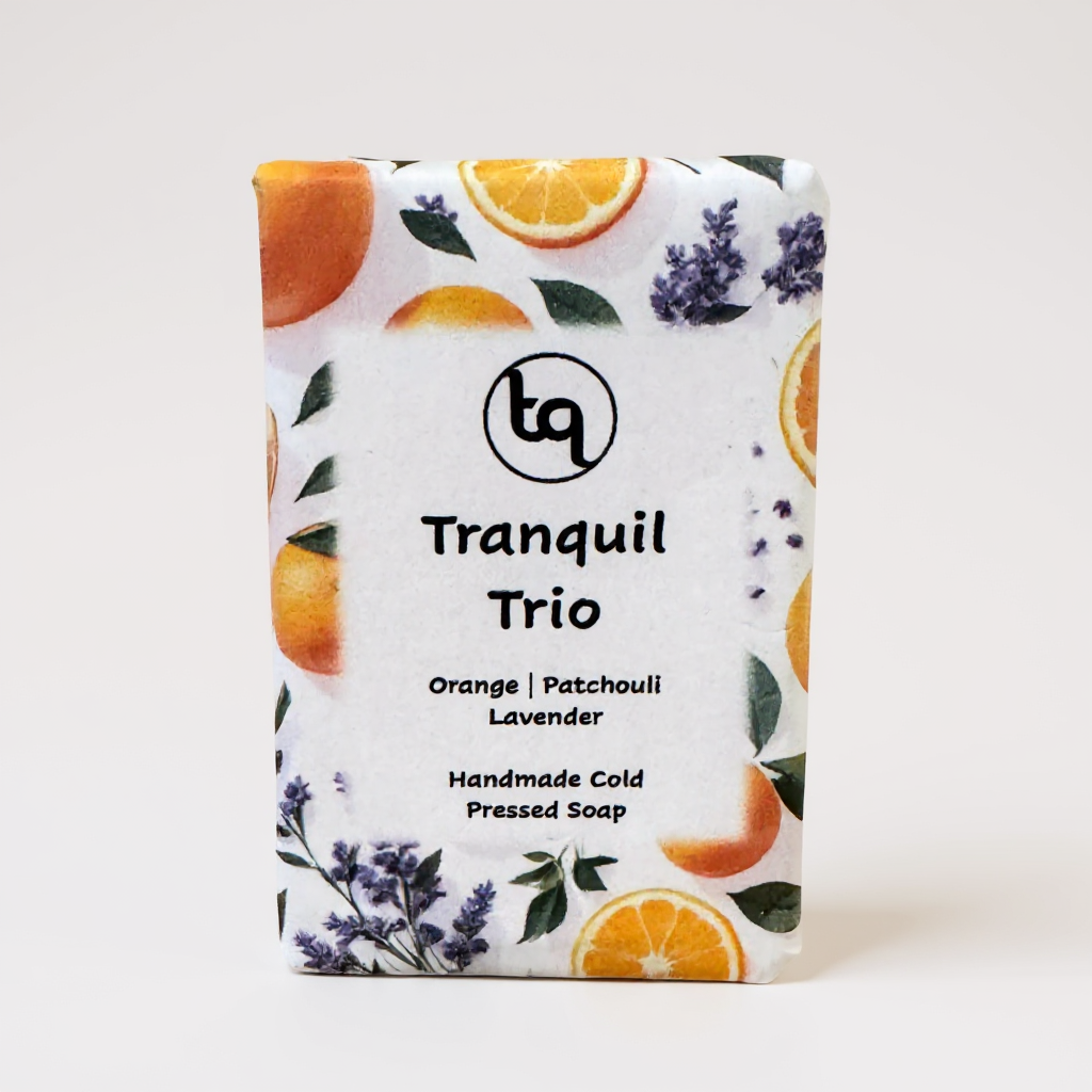 Soap bar with 'Tranquil Trio' packaging featuring oranges, patchouli and lavender on a white background