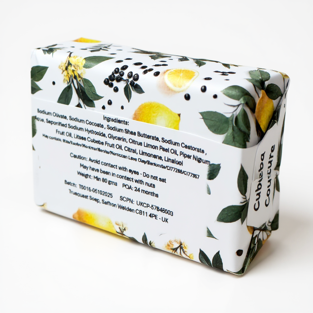Truequest Cubeba Couture soap wrapped in botanical paper with lemons, leaves and peppercorns, showing the full ingredient list on the back.