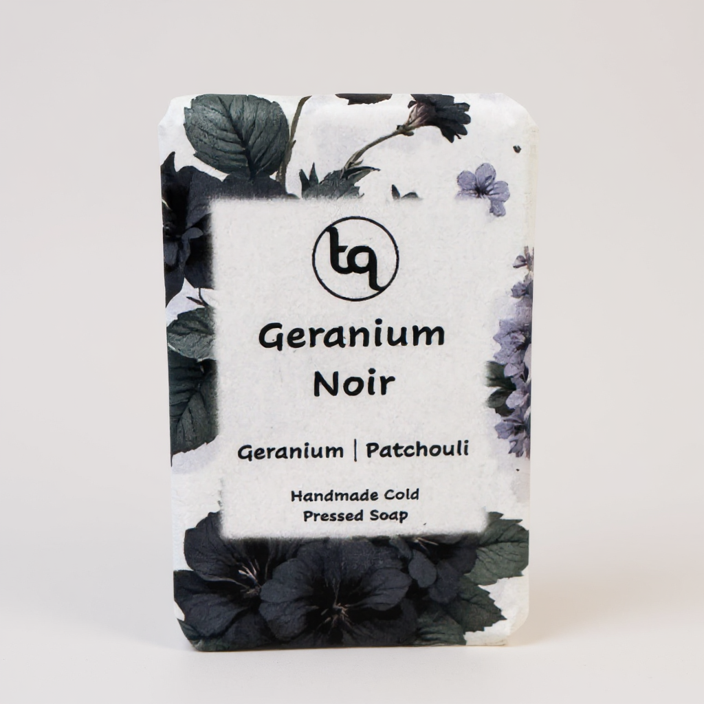 Truequest Geranium Noir soap wrapped in dark and light floral paper with geranium and patchouli illustrations.
