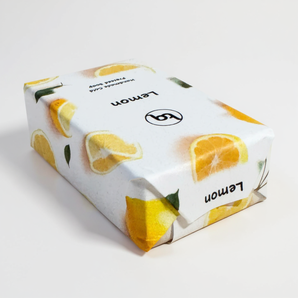 Truequest lemon cold‑process soap wrapped in white paper printed with bright citrus slices and green foliage.